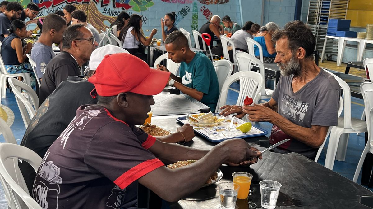 Pessoas almoçando em refeitório da rede municipal