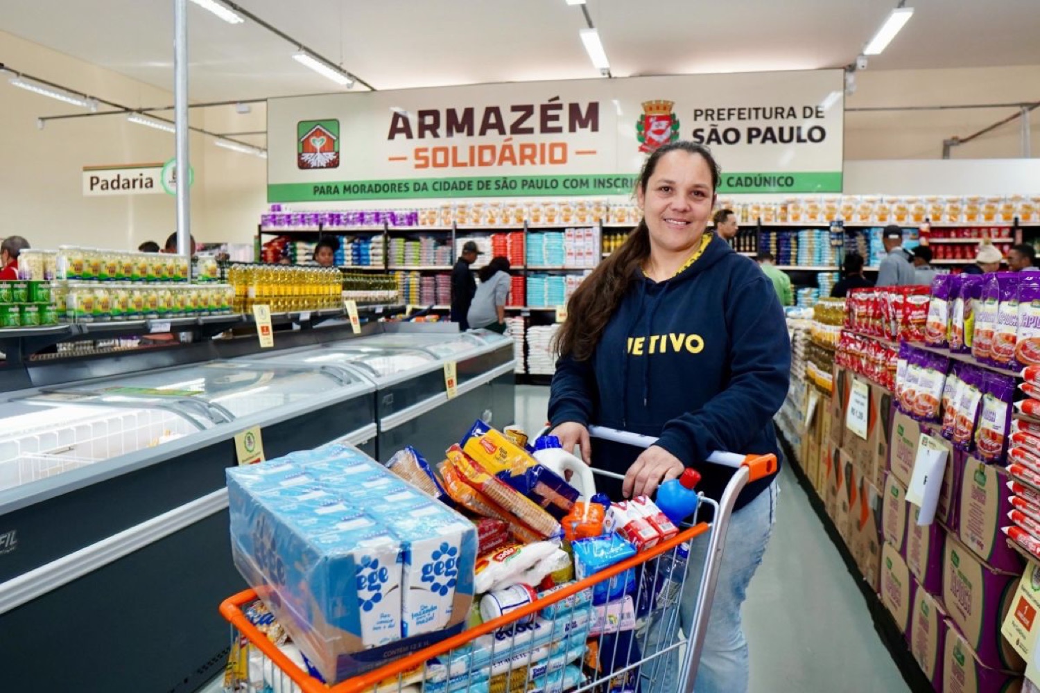 Moradora com o carrinho cheio no Armazém Solidário da Prefeitura de São Paulo